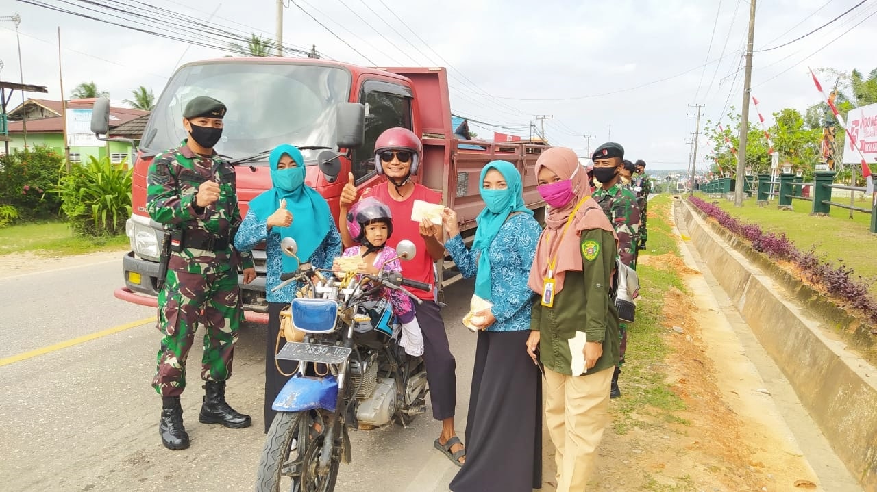 Ibu PKK Desa Giripurwa membagikan masker bersama Pendamping ProP2KPM dan anggota TNI